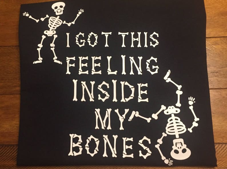 May include: Black t-shirt with a white skeleton graphic and the text "I got this feeling inside my bones".