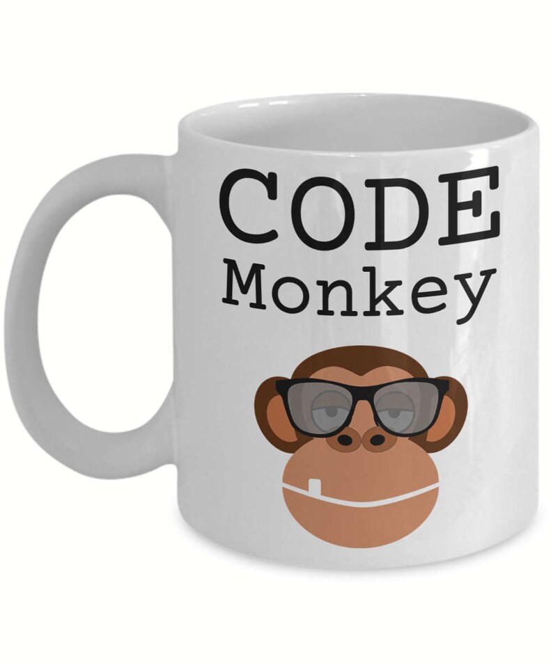May include: White ceramic coffee mug with the text "CODE Monkey" in black lettering. A cartoon monkey wearing sunglasses is below the text.