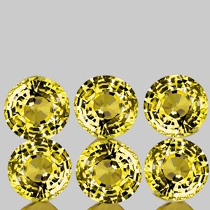May include: Six round, faceted, yellow gemstones. The gemstones are set in a circular pattern.