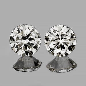 May include: Two round-cut diamonds, each with numerous facets, reflecting light. The diamonds are set on a reflective surface, creating a mirrored effect. The background is a neutral gray.