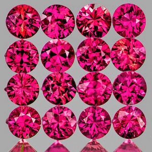 Op de afbeelding: Een verzameling van 15 ronde, gefacetteerde, roze edelstenen. De edelstenen zijn gerangschikt in een rasterpatroon.