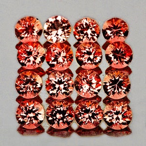 Op de afbeelding: Een verzameling van 15 ronde, gefacetteerde edelstenen in tinten oranje en rood. De edelstenen zijn gerangschikt in een rasterpatroon.