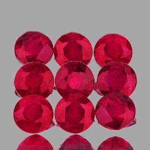 May include: Nine round, red ruby gemstones. The gemstones are faceted and have a polished finish.