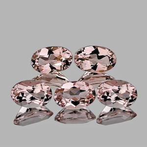 May include: Five oval-shaped, light pink gemstones with a faceted cut. The gemstones are arranged in a row, with the two largest gemstones in the center and the three smaller gemstones on either side.