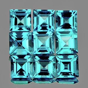 Pode incluir: Nove gemas quadradas, facetadas, de cor azul turquesa. As gemas estão dispostas em três filas de três.