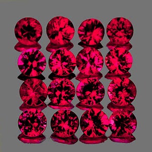 May include: Sixteen round, faceted gemstones in a vibrant red hue are arranged in a grid pattern. The gems have a reflective quality, with dark internal patterns. The background is a neutral gray, enhancing the gems' color.