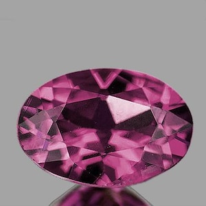 May include: A faceted, oval-shaped gemstone in shades of pink and magenta. The gem's surface reflects light, showcasing its intricate cuts and internal structure. The gemstone is set against a neutral gray background.