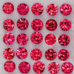 Puede incluir: Una colección de veinticuatro gemas redondas, facetadas, de color rosa brillante. Cada gema tiene un diseño complejo y multifacético, que refleja la luz. Las gemas están dispuestas en un patrón de cuadrícula sobre un fondo neutro, mostrando su color vibrante y brillo.