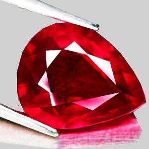 Peut inclure: Une pierre précieuse de rubis rouge foncé de forme cœur et de taille facetée. La pierre précieuse est tenue par une pince.