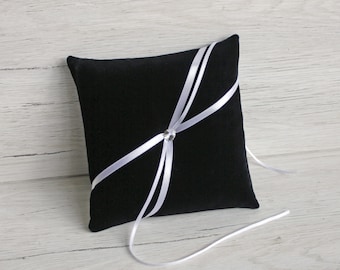 May include: Black velvet ring pillow with white satin ribbon and a crystal embellishment.