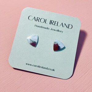 May include: A pair of silver triangle shaped earrings on a white card with the text "CAROL IRELAND Handmade Jewellery www.carolireland.co.uk"