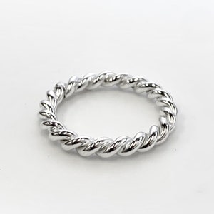 May include: A silver twisted band ring.
