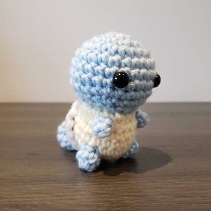 May include: A crocheted blue and white turtle amigurumi toy with black eyes.