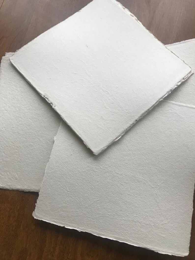 Puede incluir: Tres hojas de papel blanco texturizado con bordes irregulares. El papel es grueso y tiene una superficie rugosa.
