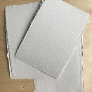 May include: Three sheets of white handmade paper with deckled edges.
