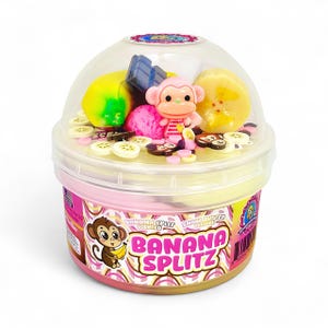 May include: A container of Banana Splitz scented slime with a clear lid. The container is pink and yellow with a cartoon monkey graphic. Inside are toy bananas, a pink monkey figurine, and other colorful toy food items.