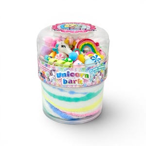 May include: A clear plastic container filled with colorful Unicorn Bark cloud dough. The container is topped with various toy candies, a rainbow, and a unicorn figurine. The container has the text "Unicorn Bark" on the side.