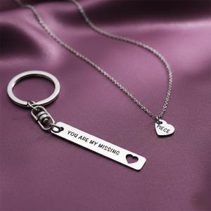 Belle Fever missing piece jewellery set styled on soft purple fabric, couple anniversary gift, romantic everyday necklace and keychain keepsake