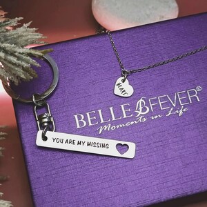 Belle Fever personalised missing piece necklace and keyring set in silver, shown in luxe purple gift box with puzzle tag engraved “You are my missing piece.”