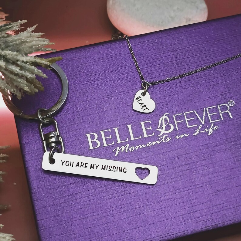 Belle Fever personalised missing piece necklace and keyring set in silver, shown in luxe purple gift box with puzzle tag engraved “You are my missing piece.”