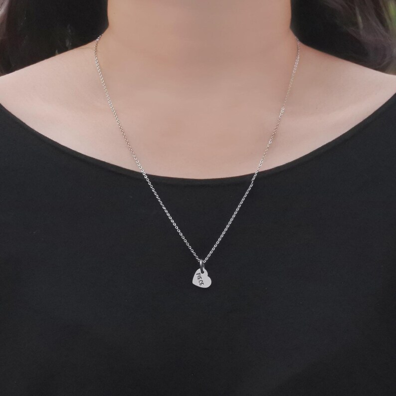 Belle Fever heart-shaped pendant from missing piece set worn as a necklace, styled against skin — minimal and meaningful for couples or anniversaries.