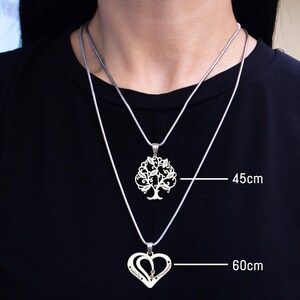 Belle Fever necklace worn layered over a black top to show the differences of chain length - an elegant way to wear your family’s love, growth, and connection close to your heart.