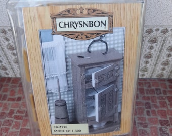 May include: A model kit for a vintage-style refrigerator, packaged in a clear plastic bag. The box features a woodgrain design and the text "CHRYSNBON" and "MODE KIT F-300".