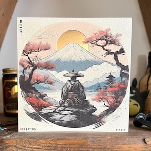 May include: Square print depicting a Japanese landscape with a figure in traditional clothing meditating before a mountain. The artwork includes a golden sun, cherry blossom trees, and the text "OLD BOY INK."
