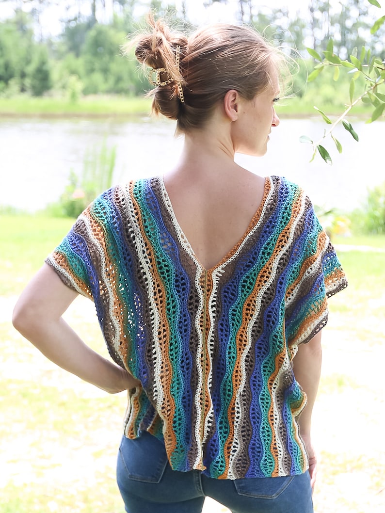 Pu&ograve; includere: Un top a righe in crochet con scollo a V e maniche corte. Il top &egrave; realizzato in una variet&agrave; di colori, tra cui blu, verde, marrone e bianco.