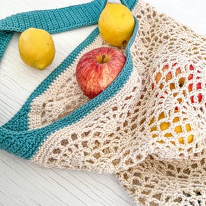 May include: A beige crochet mesh bag with teal trim, filled with a red apple and two yellow lemons.