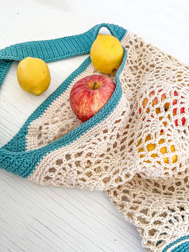 May include: A beige crochet mesh bag with teal trim, filled with a red apple and two yellow lemons.