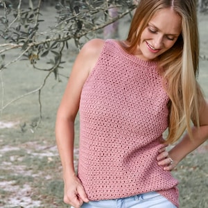 Könnte beinhalten: Ein rosa Häkel-Tanktop mit Rundhalsausschnitt und ärmellos. Das Oberteil ist mit einem strukturierten Stichmuster gearbeitet.
