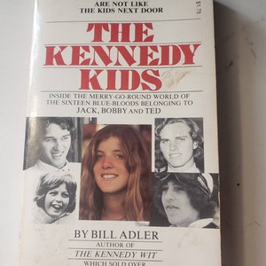 May include: Book cover with a white background and the title "The Kennedy Kids" in red and black lettering. The subtitle is "Inside the merry-go-round world of the sixteen blue-bloods belonging to Jack, Bobby and Ted". The cover features black and white photos of the Kennedy children.