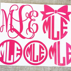 May include: A sheet of pink vinyl with four different monogram designs. The designs are all in a circle with the letters "MLE" in the center. One design has a pink bow on top of the circle.