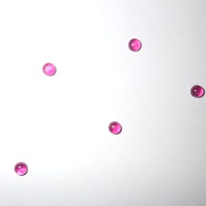 Puede incluir: Cinco piedras preciosas en forma de estrella rosa sobre un fondo blanco.