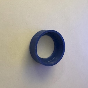 May include: A blue plastic ring with a smooth, rounded surface and a hole in the center.