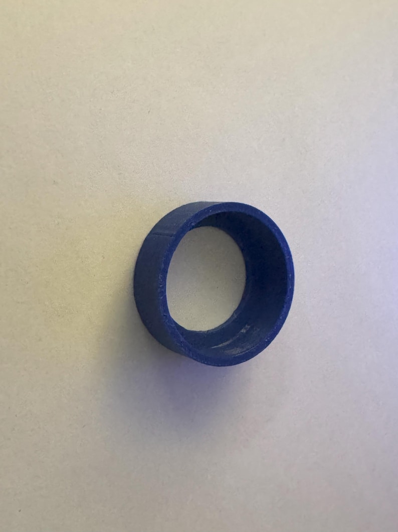 May include: A blue plastic ring with a smooth, rounded surface and a hole in the center.