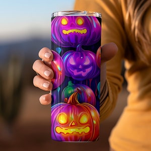 Pu&ograve; includere: Un bicchiere in acciaio inossidabile con un design colorato di zucche luminose su uno sfondo scuro.