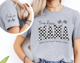 May include: Gray t-shirt with a checkered design that says "This Race Mama" and "Wears her heart on her sleeve". The checkered design is in black and white. There are two black and white checkered flags crossed on the top of the shirt.