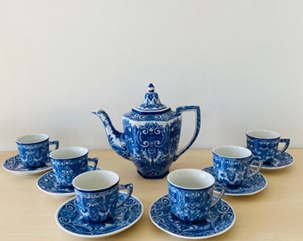 May include: A blue and white porcelain tea set with a teapot and six cups and saucers. The set features a floral design with intricate details.