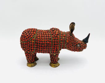Traditional brass rhinoceros figurine with coral inlay