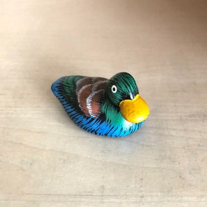 Pequeño pato decorativo de cerámica con pico amarillo