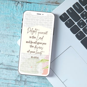 May include: A phone screen displaying a quote about finding joy in the Lord, with a watercolor background. The quote reads "Delight yourself in the Lord and He will give you the desires of your heart. Ps 37:4".
