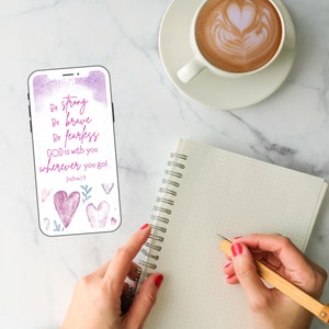 May include: A phone screen displaying a motivational quote with a watercolor background. The quote reads "Be strong, Be brave, Be fearless, GOD is with you wherever you go! Joshua 19". The background is a soft purple and pink with watercolor hearts and leaves.