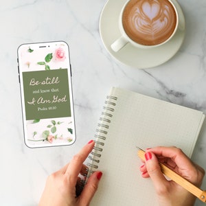 K&ouml;nnte beinhalten: Ein wei&szlig;es Smartphone mit gr&uuml;nem Hintergrund, auf dem der Text "Be still and know that I am God, Psalm 46:10" zu sehen ist. Das Telefon liegt auf einer wei&szlig;en Marmorfl&auml;che mit einer Tasse Kaffee und einem Notizbuch.