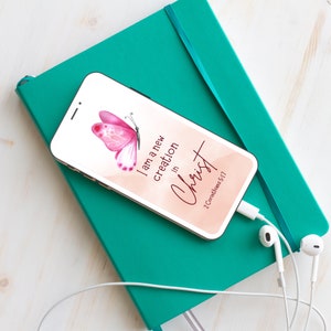 May include: A pink butterfly with a peach background and the text "I am a new creation in Christ 2 Corinthians 5:17" on a smartphone.