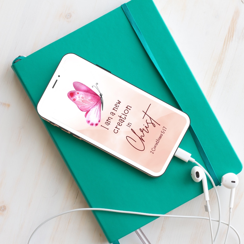 May include: A pink butterfly with a peach background and the text "I am a new creation in Christ 2 Corinthians 5:17" on a smartphone.