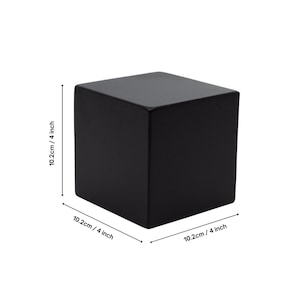 May include: A black wooden cube measuring 4 inches on each side.