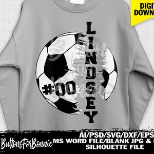 Op de afbeelding: Een grijs sweatshirt met een zwart-wit voetbalontwerp. De voetbal is in twee&euml;n gedeeld met de naam "LINDSEY" verticaal langs de zijkant geschreven. Het nummer "#00" staat op de voetbal.