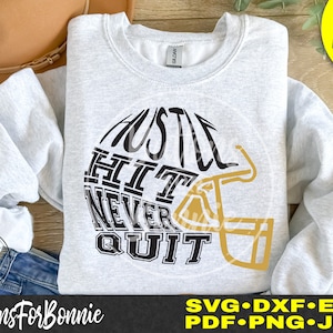 May include: A gray sweatshirt with the words "Hustle Hit Never Quit" in black text inside a gold football helmet graphic.